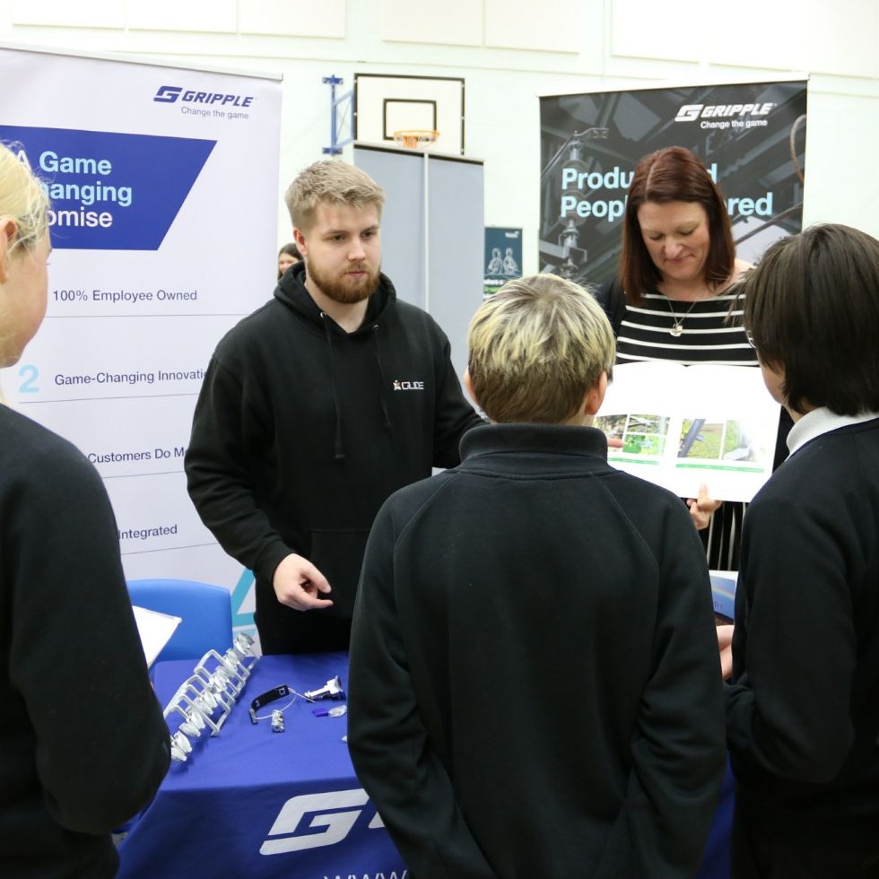 students talk to a stall holder at the fair